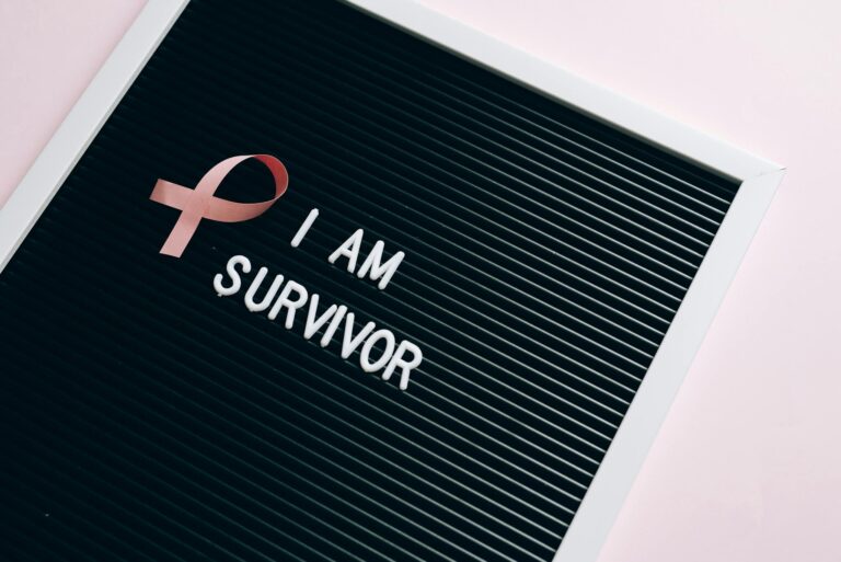 Letter board with pink ribbon symbolizing breast cancer survival.