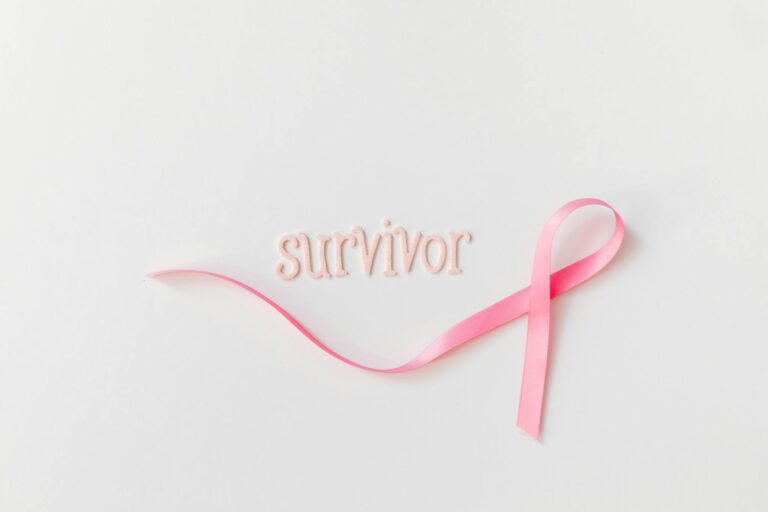 Pink ribbon next to 'survivor' text symbolizing breast cancer awareness and hope.