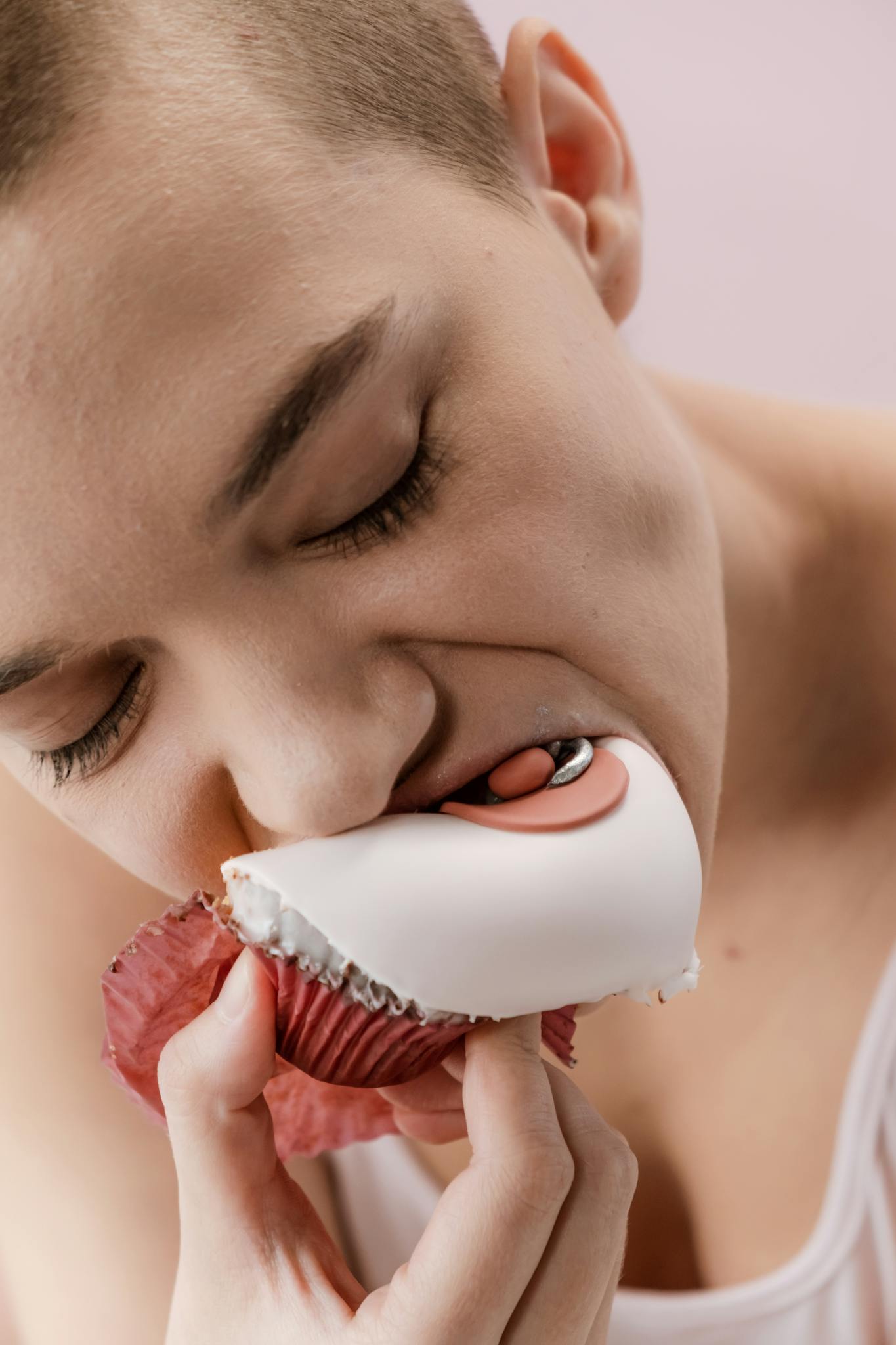 Woman eating a symbolic cupcake, promoting breast cancer awareness.